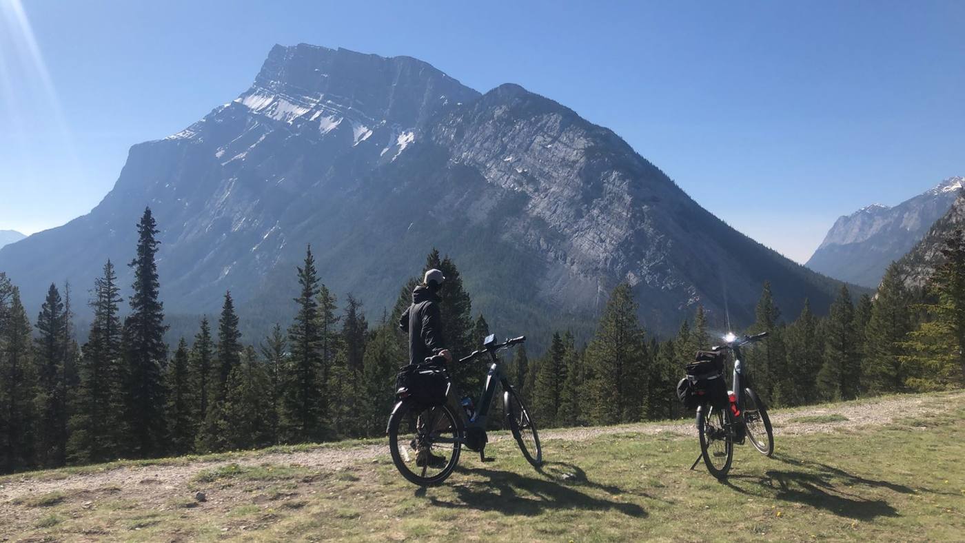 Two bikes on a grassy rise below Mount Rundle