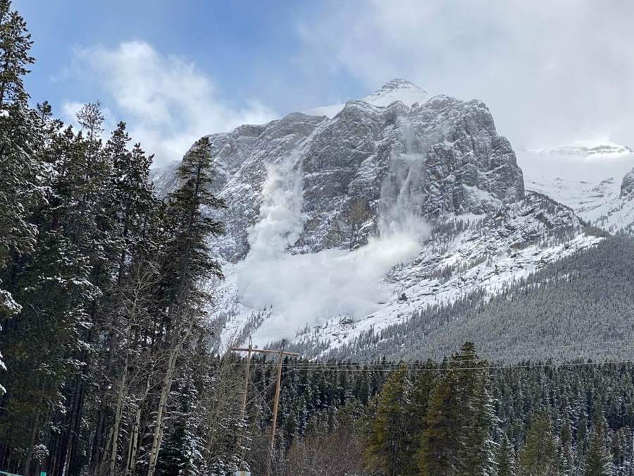 Snow blowing off a steep peak above the forest near Canmore