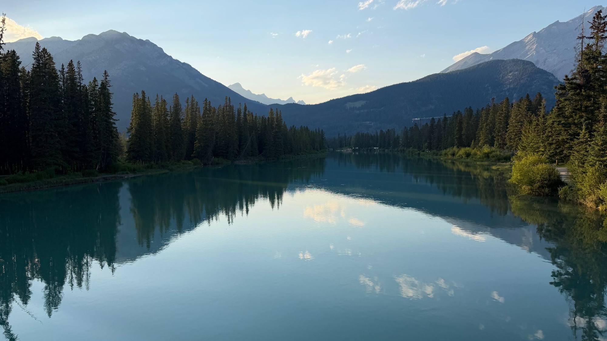 Mountains reflected in the still Bow River